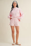 Woman wearing a pink outfit on a beige background