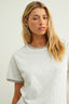 Woman wearing a light gray t-shirt against a plain background