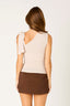 Woman wearing a beige sleeveless top and brown skirt on a white background