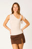 Woman wearing a beige top and brown skirt on a white background