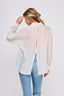 Woman wearing a sheer white blouse with a blurred background