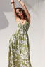 Woman wearing a green floral dress against a white background