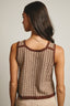 Woman wearing a brown and beige patterned sleeveless top against a neutral background