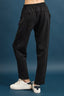 Black pants worn by a person on a blue background