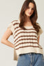 Woman wearing a striped sweater and jeans against a plain background