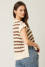 Woman wearing a striped sweater and jeans on a plain background
