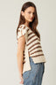 Woman wearing a striped sweater and jeans against a plain background