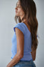 Woman wearing a blue top with ruffled sleeves 