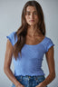 Woman wearing a blue top with ruffled sleeves 