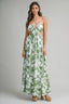 Woman wearing a green and white floral dress on a gray background