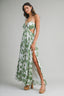 Woman wearing a green and white floral dress on a gray background