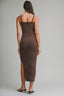 Woman wearing a brown slip dress with a backless design on a gray background
