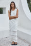 Person wearing a white lace asymmetrical designed skirt and matching top.