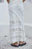 Person wearing a white lace asymmetrical designed skirt