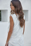 Woman wearing a white lace top and skirt against a white background
