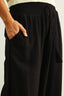Black pants with a drawstring waist on a plain background