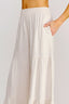 White tiered skirt worn by a person on a plain background