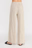 Beige pleated pants worn by a person on a white background