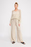 Woman wearing a beige knitted outfit on a white background