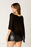 Woman wearing a black top and black leather shorts on a white background