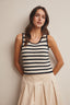 Woman wearing a striped sleeveless top against a plain background