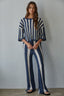 Woman wearing a blue and white striped outfit against a gray background