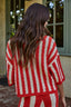 Person wearing a red and white striped outfit standing outdoors.