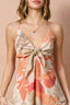 Woman wearing a blush floral maxi dress against a beige background