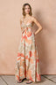 Woman wearing a blush floral maxi dress against a beige background