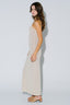 Woman wearing a beige sleeveless dress against a white background