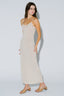 Woman wearing a beige slip dress against a white background