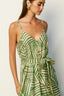 Woman wearing a green and white patterned dress against a plain background