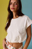 Woman wearing a white crop top against a multicolored background