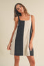 Woman wearing a navy and beige dress against a plain background