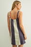 Woman wearing a striped dress with a plain background