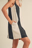 Woman wearing a navy and beige dress against a plain background