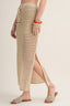 Person wearing a beige woven skirt on a plain background