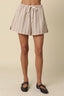 Striped shorts worn by a person on a beige background