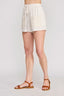 Person wearing white shorts on a plain background