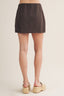Brown mini skirt worn by a person on a beige background
