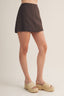 Person wearing a brown skirt on a plain background
