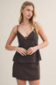 Woman wearing a brown cami tank top with a beige background