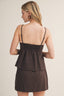 Woman wearing a brown cami tank top with a beige background