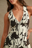 Woman wearing a black floral dress against a neutral background