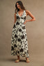Woman wearing a black floral dress against a beige background