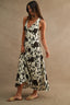 Woman wearing a floral dress against a beige background