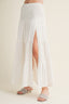 White tiered skirt with a slit on a plain background