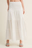 White tiered skirt worn by a person on a beige background
