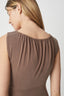 Brown sleeveless top worn by a person on a white background