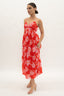 Woman wearing a red floral dress on a white background